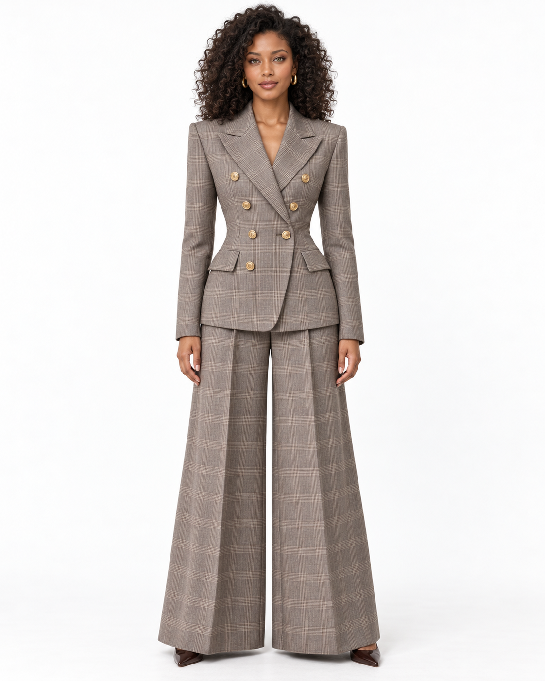 A model wearing a two-piece brown plaid double-breasted blazer and matching wide-leg trousers, featuring gold buttons on the blazer, set against a plain white studio background.
