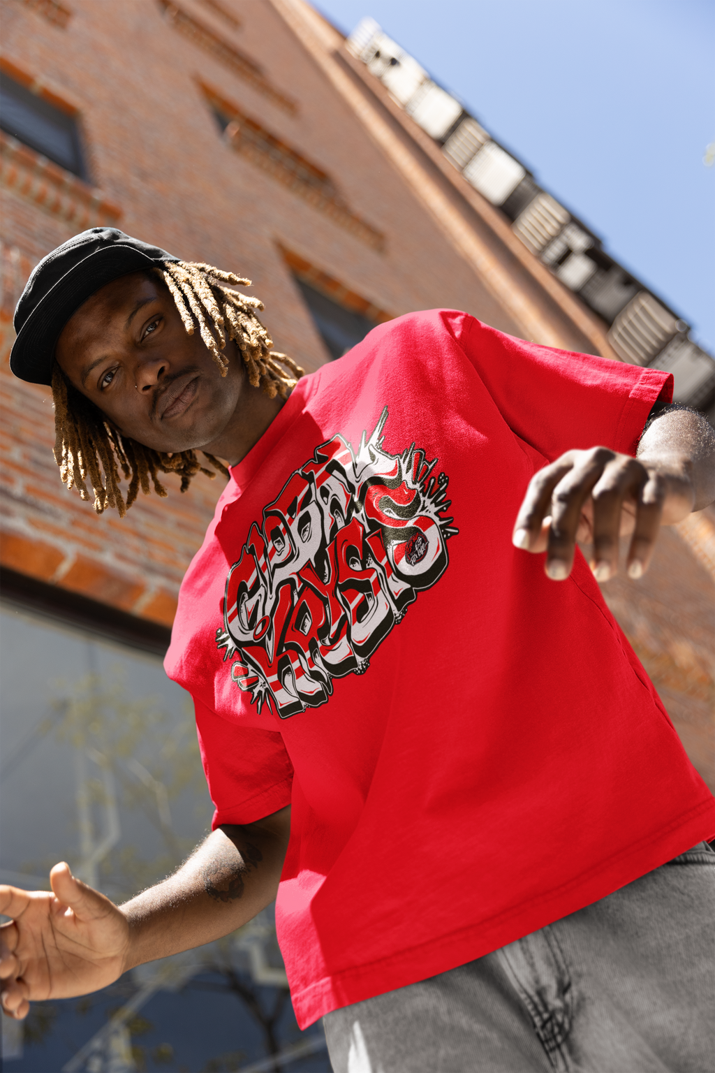Person wearing a red soft cotton t-shirt with global crisis graphic design in an urban setting